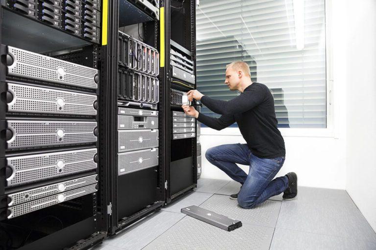 A man performing Managed IT on a server in a data center.